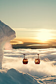 Skilift über den Wolken bei Sonnenuntergang