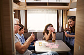 Family playing cards in camper van