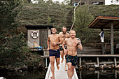Happy men running on jetty