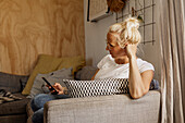 Woman using cell phone on sofa