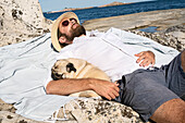 Man sunbathing with pug