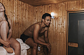 Paar sitzend in der Sauna