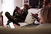 Familie benutzt Smartphones im Wohnzimmer