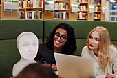 Freunde sitzen zusammen in der Bibliothek