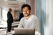 Man with laptop sitting in office
