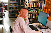 Frau benutzt Computer in der Bibliothek