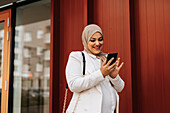 Smiling woman using cell phone