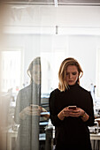 Woman in office with mobile phone