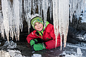 Boy hiding in cave with ice
