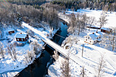 Luftaufnahme eines Dorfes mit Fluss und Brücke