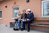 Schulfreunde sitzen auf einer Bank und lernen