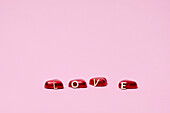 Herzförmige Bonbons auf rosa Hintergrund
