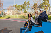 Portrait of teenage friends sitting in schoolyard