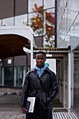 Young man standing in front of modern building