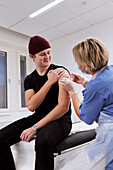 Smiling young man getting vaccinated against Covid-19