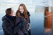 Smiling female couple hugging at icy river