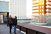 Smiling female couple walking in modern neighborhood