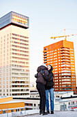 Female couple hugging in modern neighborhood
