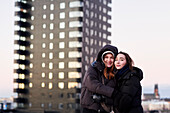 Portrait of smiling female couple against apartment block