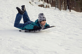 Boy sledging at winter