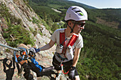 Mann beim Bergsteigen mit Ausrüstung
