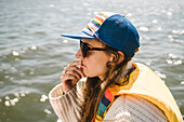 Young woman in baseball cap against sea