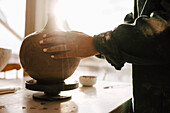 Hands of woman making clay vase