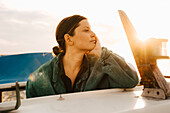 Young woman on motorboat at sunset