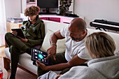 Family relaxing in living room and using tablets