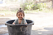 Girl bathing in plastic basin