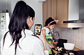 Mädchen fotografiert Tochter in der Küche