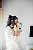 Woman in kitchen using cell phone