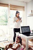 Woman in kitchen using cell phone