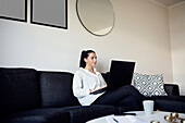 Woman on sofa using laptop