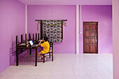 Boy using laptop in pink room