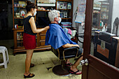 Senior man getting haircut in hair salon