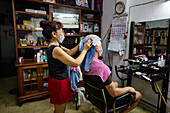 Älterer Mann wird im Friseursalon mit einem Handtuch getrocknet