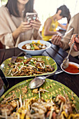 Menschen essen asiatisches Essen am Tisch