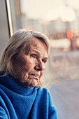 Senior woman looking through window