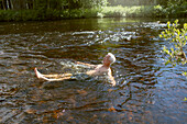 Mann schwimmt im Fluss