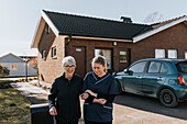 Home caretaker going on walk with senior woman