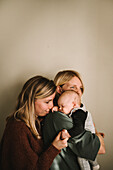 Mothers hugging sleeping newborn baby