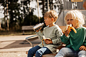 Kinder beim Essen auf dem Spielplatz