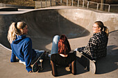 Teenager-Mädchen mit Skateboards im Skatepark sitzend