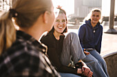 Smiling teenage girls sitting in skatepark