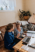 Home caretaker helping senior woman with bills