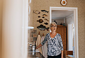 Ältere Frau steht in der Küche