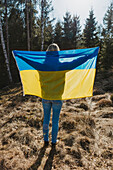 Rear view of woman holding Ukrainian flag