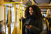 Woman in bus holding cell phone