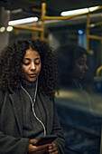 Woman in train using cell phone